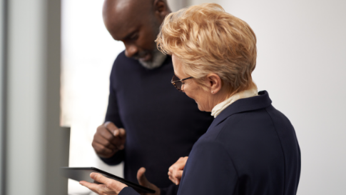 Two people looking at a tablet together