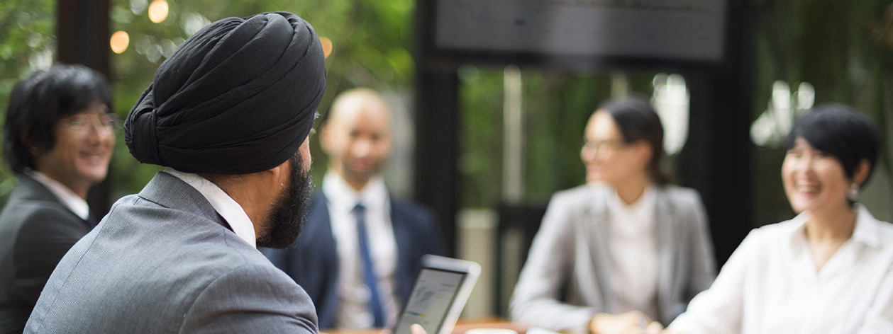 group of five business people sitting at a table for a meeting